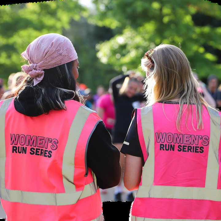 Two volunteers in pink Women's Run Series hi-vis vests